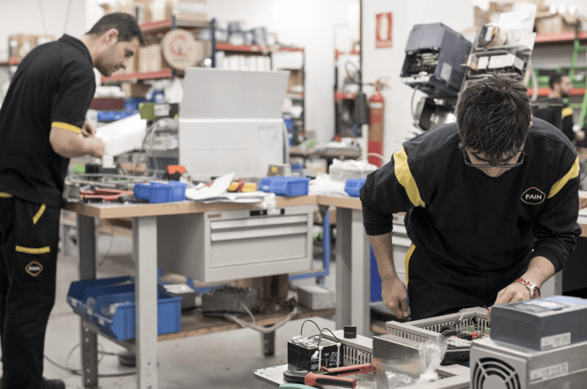 Deux employés FAIN en train de travailler dans l'usine pour sans doute développer de nouveaux produits.