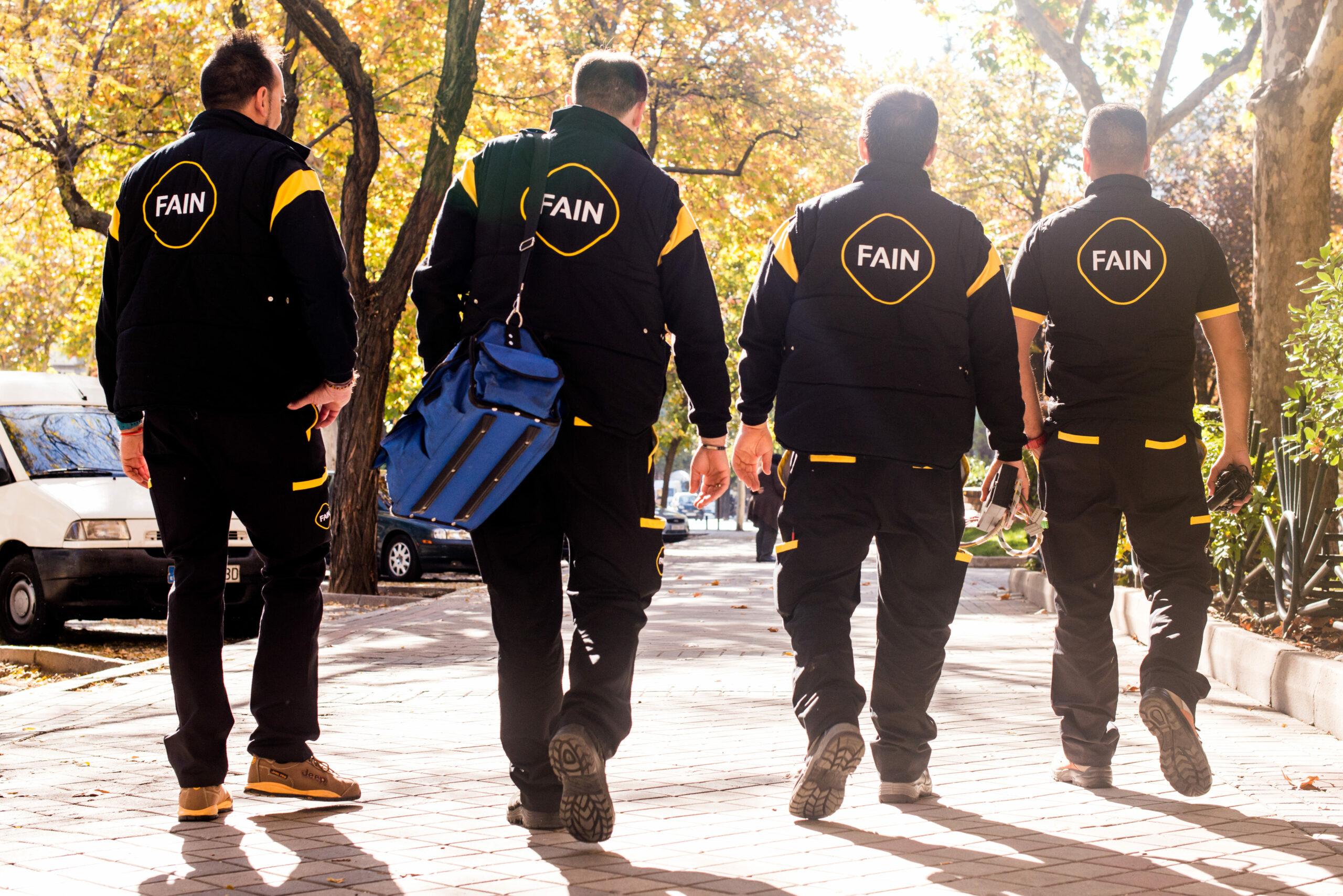 Les techniciens de la FAIN, de dos à la caméra, en uniforme.
